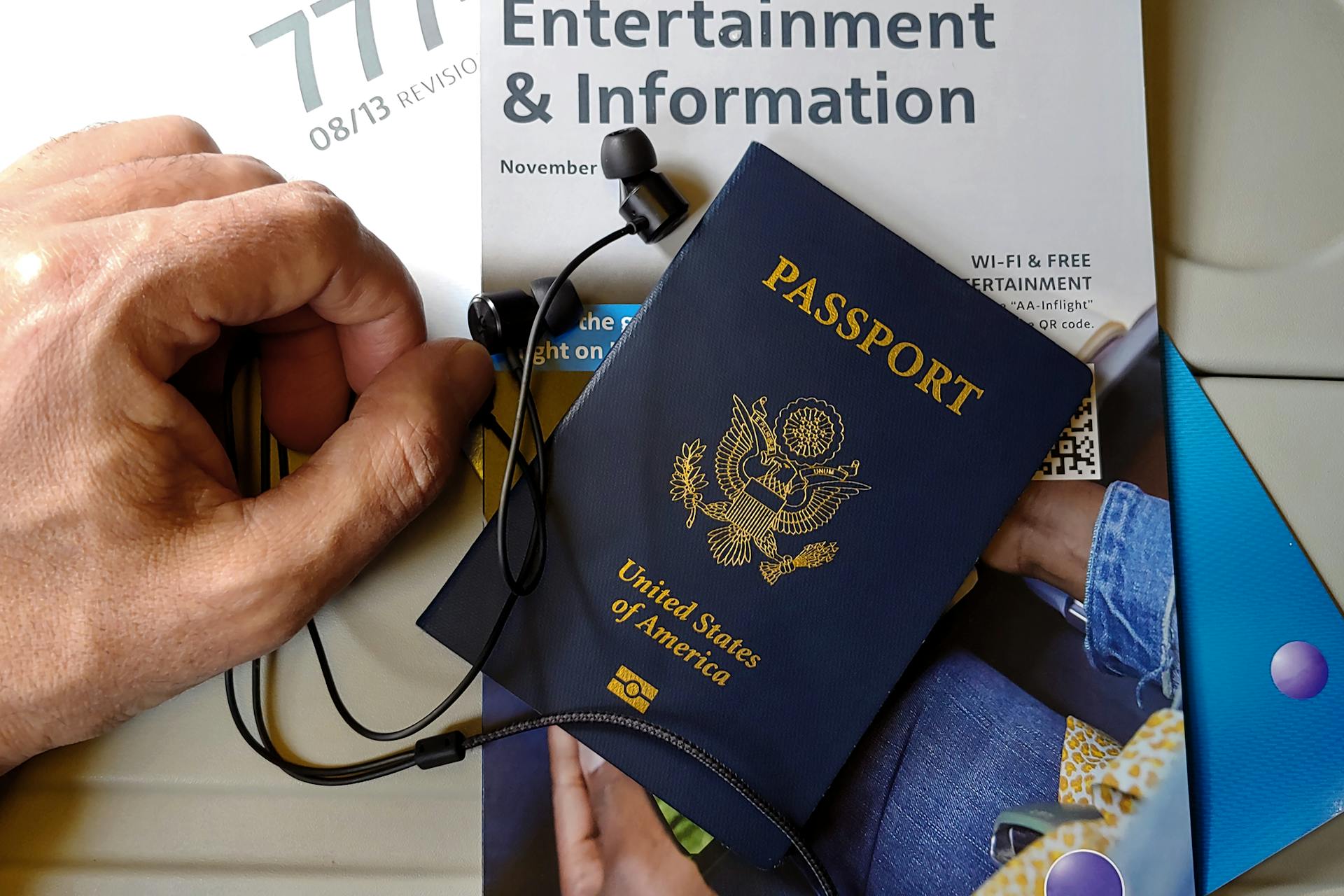 US Passport with Travel Essentials on Airline Seat